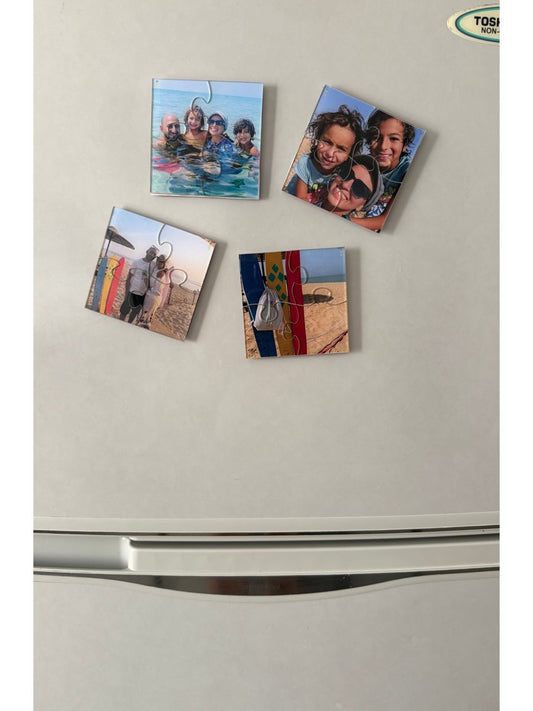 Four photo magnets on a refrigerator with family images.