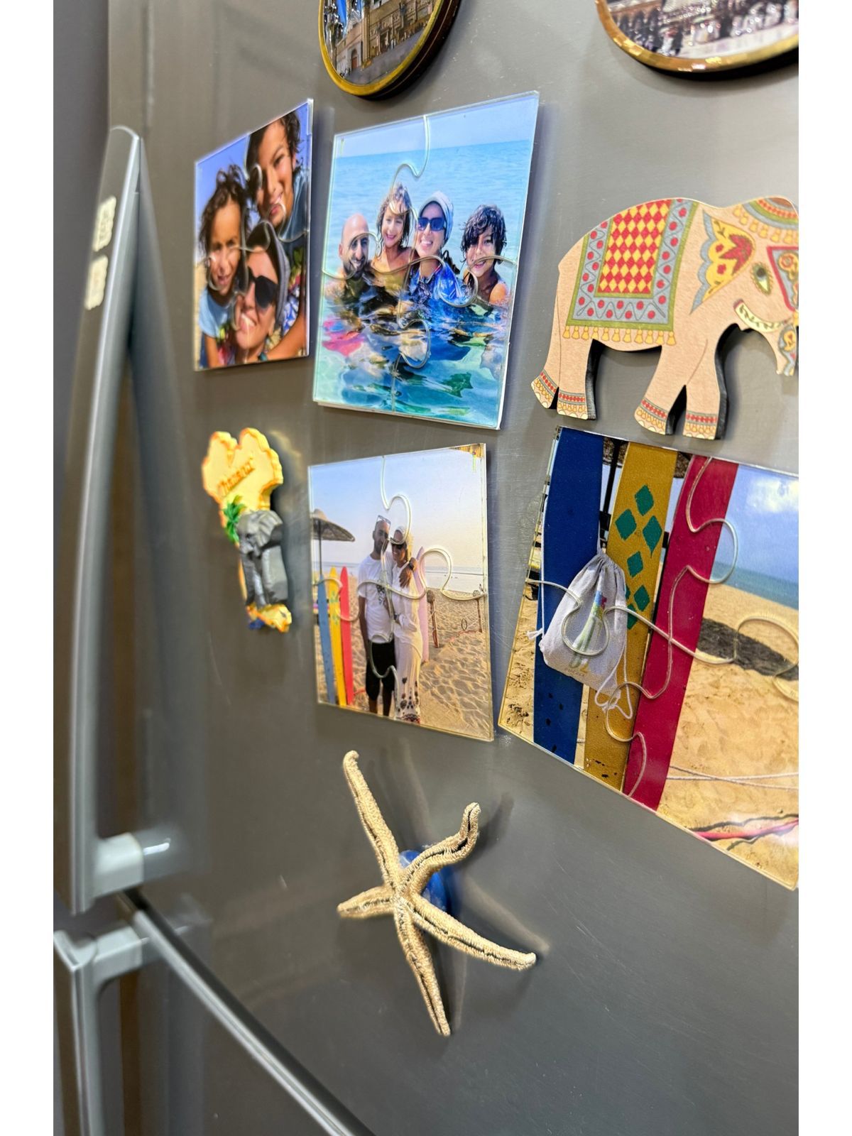 Fridge with various magnets including family photos, an elephant, and a starfish.